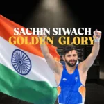 Sachin Siwach Gold celebration after winning the men's 60 kg boxing title at the Glasgow 2026 Commonwealth Games, posing with raised arms in front of the Indian flag.