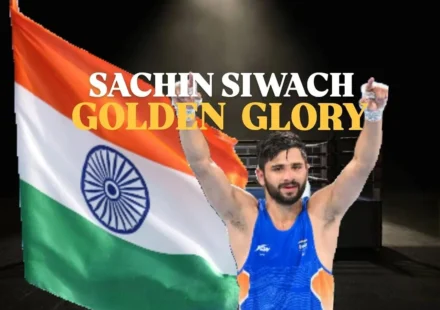 Sachin Siwach Gold celebration after winning the men's 60 kg boxing title at the Glasgow 2026 Commonwealth Games, posing with raised arms in front of the Indian flag.